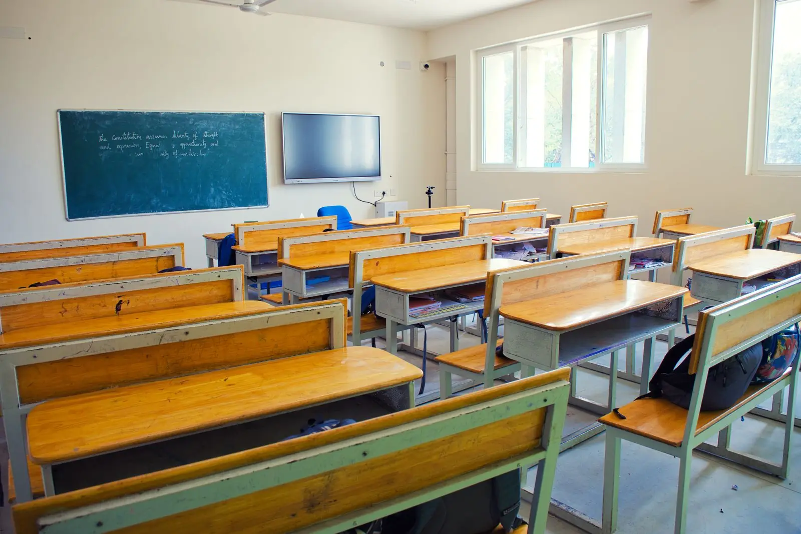 Empty classroom with wooden desks and a blackboard in a Chennai school